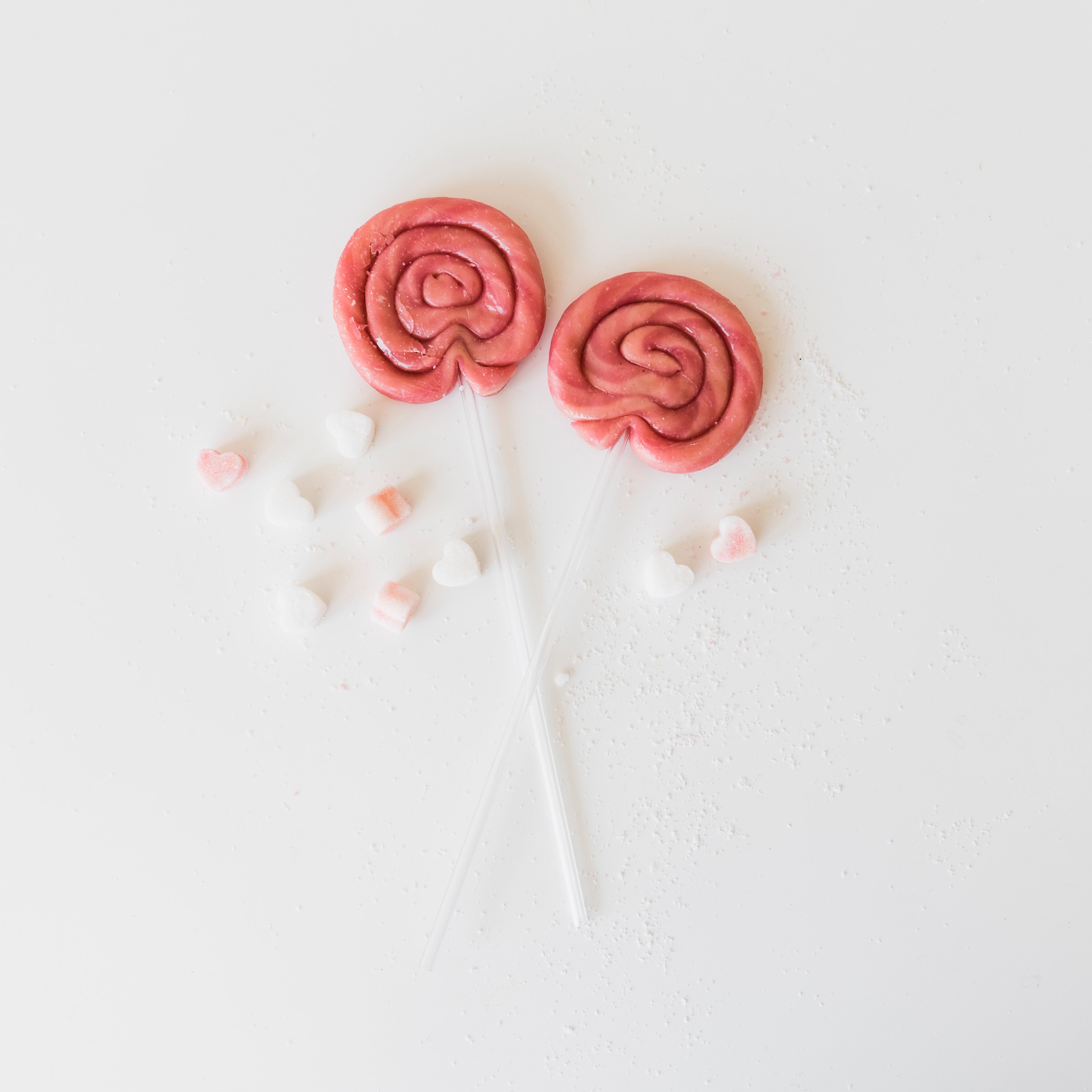 high-angle-view-two-lollipops-with-heart-shape-candies